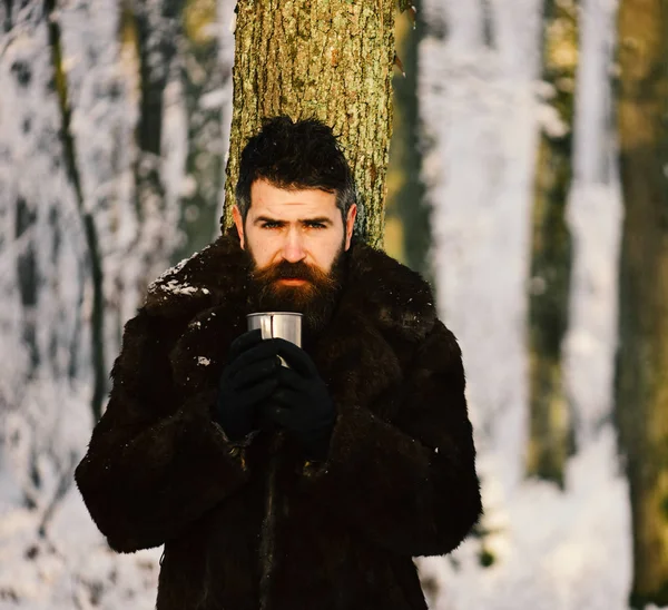 El hombre con abrigo de piel sostiene una copa de metal. Macho con barba — Foto de Stock