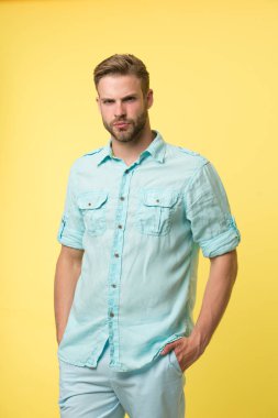 Adam rahat bir şekilde poz veriyor. Sakallı ve saç stili olan yakışıklı adam.