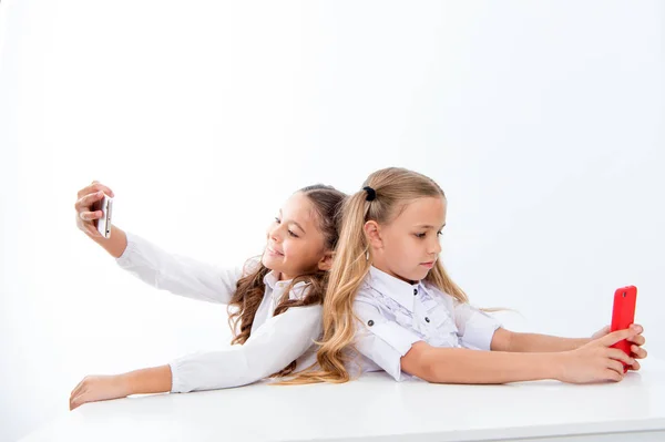 手机的依赖性和自拍。小孩子们在学校的电话里自拍, 被隔离在白色, 复制空间。学生生活与手机依赖性 — 图库照片