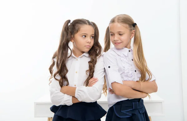 Le bambine in uniforme scolastica tengono le braccia incrociate. Torna a scuola e stai bene con l'uniforme della scuola nuova. bambine . — Foto Stock