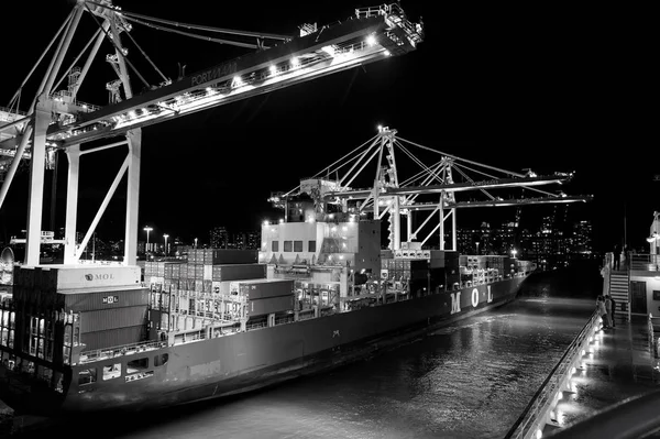 Miami, EE.UU. - 23 de noviembre de 2015: puerto o terminal con iluminación nocturna. Puerto de contenedores marítimos con contenedores de carga, grúas por la noche. Carga, envío, entrega, logística, mercancía — Foto de Stock