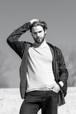 Erkek moda ve stil. Rahat kıyafet dokunmatik saç güneşli açık, moda sakallı adam. Mavi gökyüzü, perspektif maço kürsüye. Perspektif, gelecek, özgürlük.