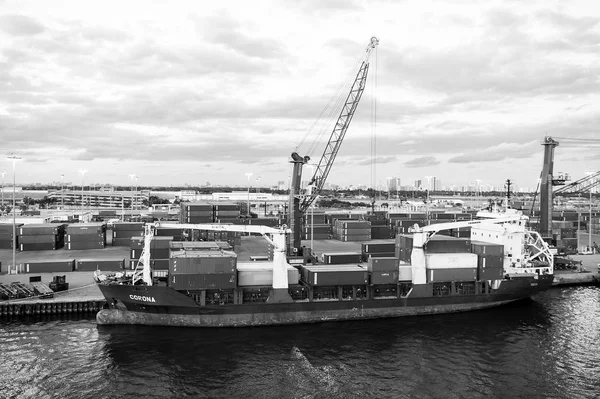 Miami, EE.UU. - 01 de marzo de 2016: buque de carga en puerto de contenedores marítimos con contenedores y grúas. Puerto o terminal en el cielo nublado. Logística de envío de mercancías y concepto de mercancía — Foto de Stock