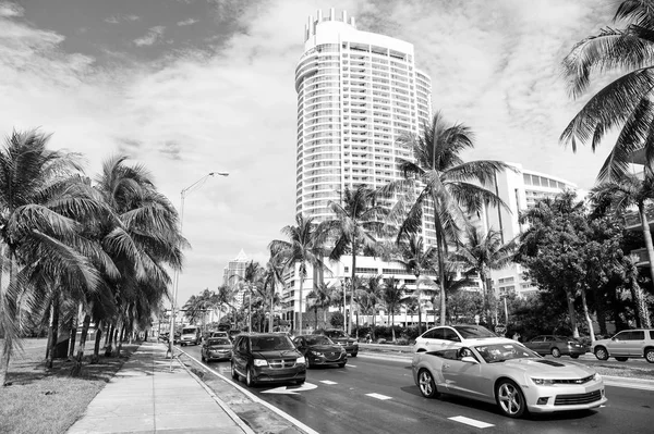 美国迈阿密-2016年1月10日: 汽车在城市景观上行驶。街道道路与运输和绿色棕榈。城市交通和现代建筑在多云的天空。旅行和旅行运输 — 图库照片
