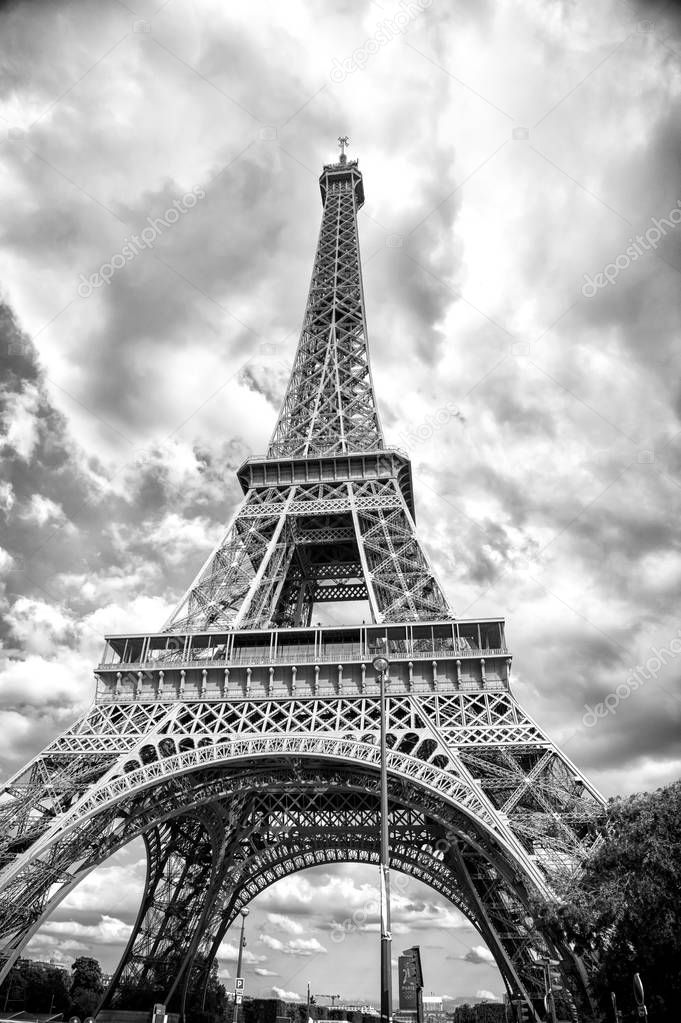 Eiffel Tower in Paris, France. Tower on cloudy sky. Architecture structure and design concept. Summer vacation in french capital