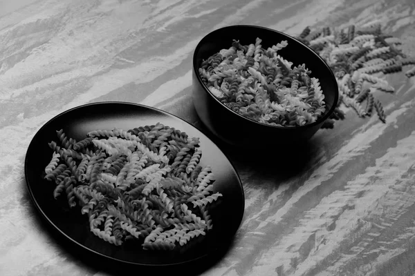 Delicious colorful italian pasta in two balck ceramic plate — Stock Photo, Image