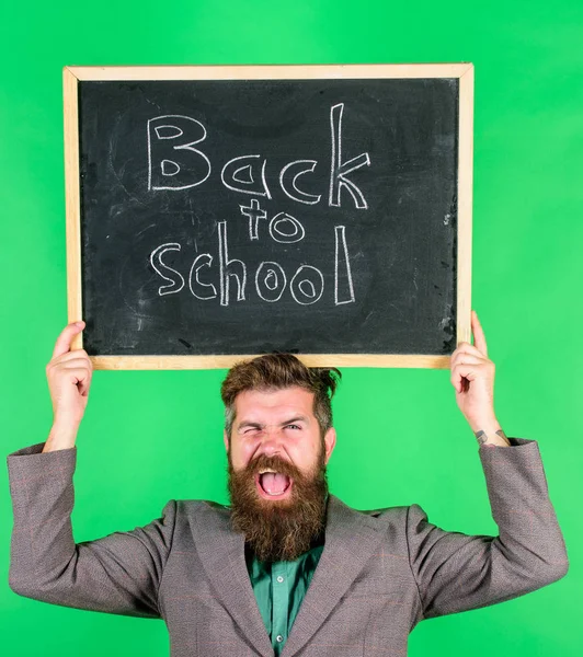 Şuna bir bak. Öğrenciler için sunuyoruz. Okula geri özel teklif. Sakallı adam öğretmen blackboard yeşil arka plan üzerinde okul yazıt için geri tutar. Özel indirim indirim ve satış okul sezonu — Stok fotoğraf