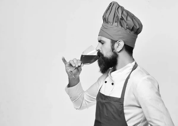 Cuisiner avec le visage concentré dans des boissons uniformes bordeaux alcool. — Photo