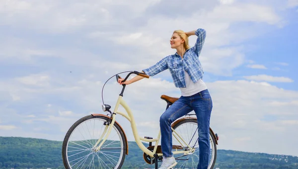Health benefits of cycling. Reasons to ride bike. Woman rides bicycle sky background. Increase muscle strength and flexibility by riding bike. Benefits of cycling every day. Girl ride cruiser bicycle.