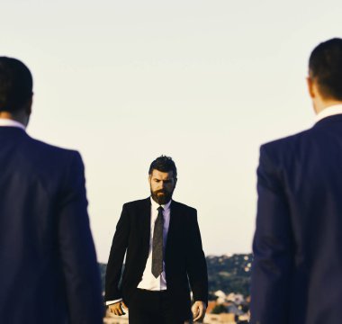 Sakallı ve ciddi yüzlü bir adam öne doğru yürüyor, yaklaş..
