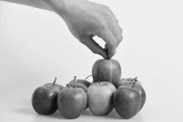 Mano masculina sostiene la manzana roja clara por encima de otras frutas . — Foto de Stock