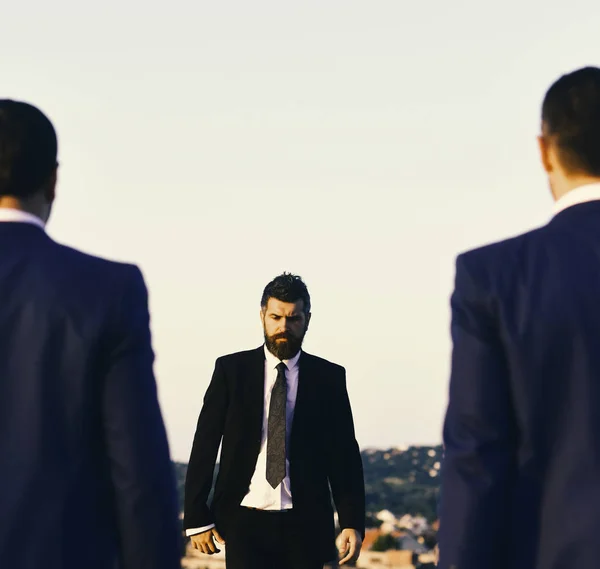 Man with beard and serious face walks forward, close up.