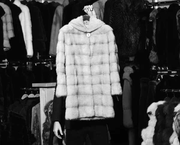 Beige mink fur coat on furry coats background.