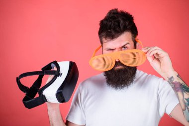 Hangi gözlük louvered veya sanal seçin. Adam ne tercih gerçek veya sanal karar. Sakallı adam hippi sanal gerçeklik kulaklık ve çok güneş gözlüğü kırmızı arka plan ile. Alternatif gerçeklik