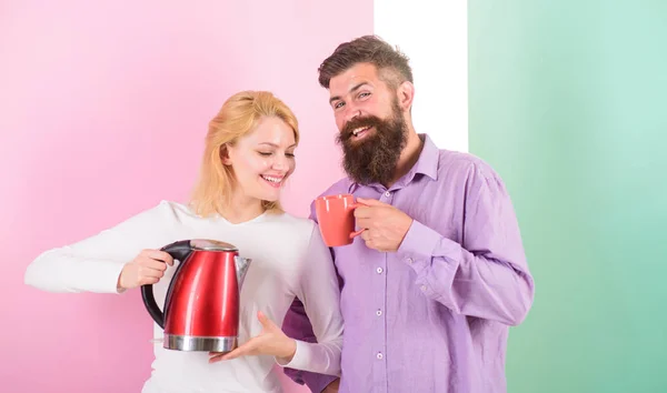 La tecnología moderna hace la vida más fácil. Ahorre tiempo tecnología moderna. Empezando el día juntos. Pareja preparar la bebida de la mañana hervidor eléctrico. La tetera eléctrica hierve el agua rápidamente. Preparar la bebida en minutos — Foto de Stock