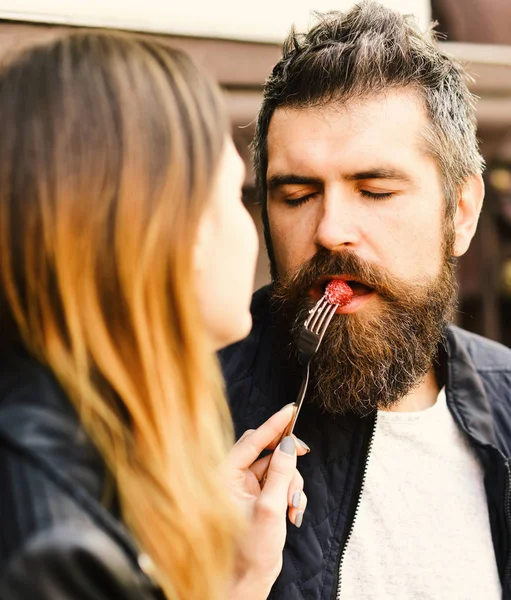 Meisje voedt bebaarde jongen met framboos op vork — Stockfoto