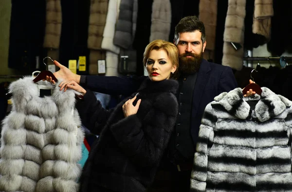 Customer with beard and woman buy furry coats