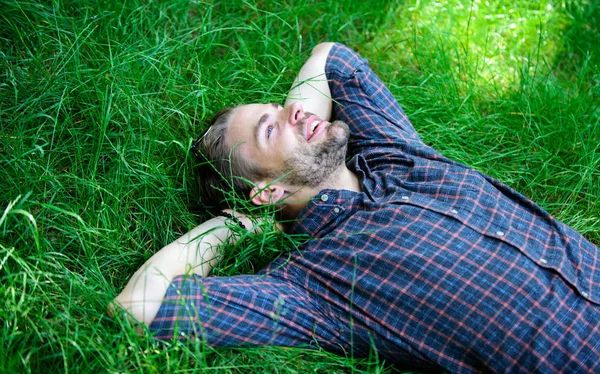 Blíže k přírodě. Příroda ho naplňuje čerstvosti a inspiraci. Guy neoholený muž ležel na louce zelené trávy. Ten šťastný a pokojný vychutnat čerstvosti trávy. Muž vousatý bokovky spojí s přírodou — Stock fotografie