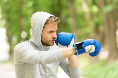 Saldırı ya da savunma her zaman hazır olsun. Sporcu konsantre boks eldivenleri. Sporcu odaklı yüz sporu eldivenleri dövüş becerileri doğa arka planı. Yakışıklı boksör.