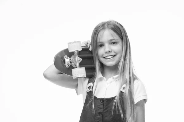 Patinador infantil sonriendo con longboard. Nacida para ser una chica patinadora. Sonrisa de niña pequeña con tabla de skate aislada en blanco. Niño monopatín con el pelo largo. Actividad deportiva y energía. Infancia y juego activo — Foto de Stock