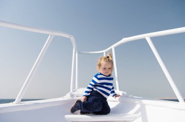 Dünya çapında. Çocuk şirin denizci yat güneşli. Çocuk denizci deniz seyahat serüveni. Çocuk çok güzel denizci gömlek beyaz yat seyahat dünya çapında çizgili. Erkek bebek keyfini çıkarın tatil seyahat gemisinde