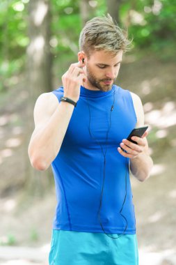 Müzik en iyi arkadaşı çalıştırmak için. Adam atlet meşgul yüz kadar çalma listesi, Doğa arka plan ayarlayın. Sporcu eğitim kulaklık müzik dinle. Kıl fitness izci veya pedometer ile sporcu
