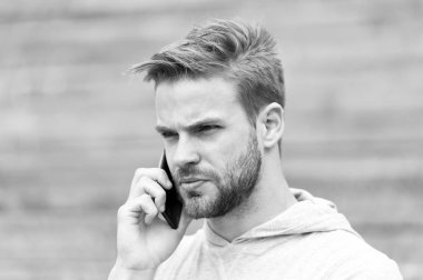 Sakallı adam akıllı telefon, merdiven ile kentsel arka plan ile yürür. Ciddi yüz sakallı smartphone üzerinde konuşuyor. Adam cevap arama smartphone üzerinde yoğunlaşmıştır. İletişim kavramı