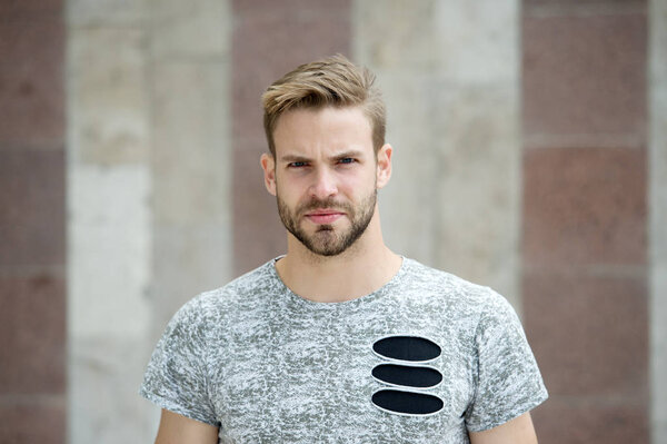Cool style. Guy bearded attractive care about style and appearance. Man with bristle strict face urban background. Man with beard or unshaven guy looks handsome and cool. Metrosexual concept