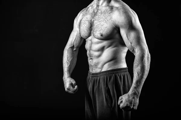 Concepto muscular. Torso muscular con seis abdominales de hombre, blanco y negro. hombre fuerte aislado en negro . — Foto de Stock