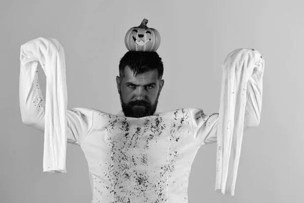 Halloween, concepto de cultura y tradiciones. Chico con barba sostiene la calabaza — Foto de Stock