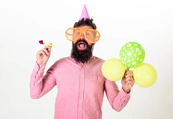 Conceito surpresa. Hipster em óculos de sol gigantes comemorando aniversário. Homem com barba e bigode no rosto surpreso detém balões de ar, fundo branco. Cara em chapéu de festa com chifre de festa celebra — Fotografia de Stock