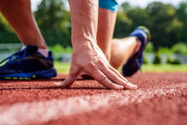 Flexibilitet är förmågan att sträcka leden att begränsa intervallet rörlighet. Gemensamma vård för löpare. Ultimata rättsmedel. Hand av sportsman på löparbana låg startposition. Löpare som är redo att gå närbild — Stockfoto