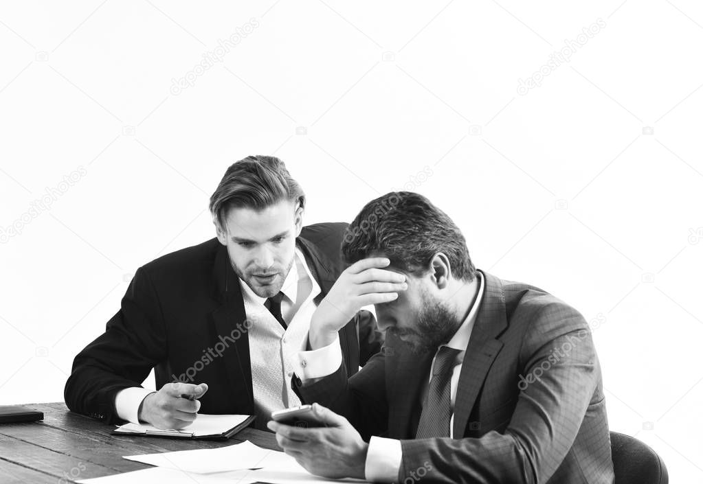 Financial crisis, credit debt, bankruptcy. Men in with tired, worried faces read business news. Business partners in formal suits look at smartphone. Business failure, bad luck, lack of money concept