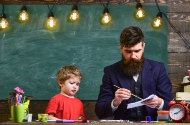 Çocuk ve meşgul yüz boyama, resim öğretmeni. Sanat ders kavramı. Öğretmen sakallı, baba çizim arka plan kara tahta sınıf, küçük oğlu yakınındaki, takılmak iken