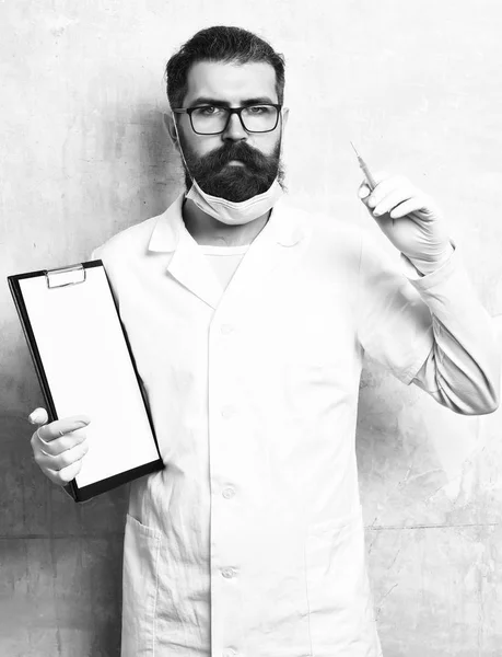 Bearded brutal caucasian doctor or postgraduate student holding clipboard — Stock Photo, Image