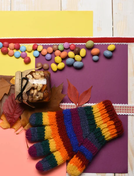 Džbán plný ořechů a medu, pruhované pletené rukavice, listy — Stock fotografie