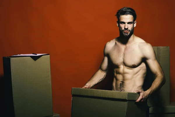 Guy with sexy naked torso holds box in front.