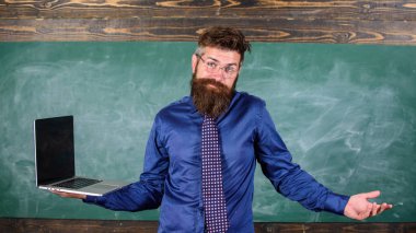 Yenilikçi öğretmen ifade tutar dizüstü karıştı. Uzaktan eğitim sorunları. Öğretmen sakallı adam iş modern dizüstü kara tahta arka plan ile karıştı. Modern teknolojiler kullanarak öğretim sorunları