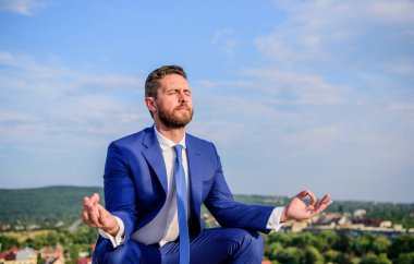 İşadamı resmi takım elbise lotus poz ve meditasyon oturup açık havada. Adam zihnini açık tutmaya çalış. Gevşeme tekniği. Ruhu içinde sakin tutmak. Girişimci bulmak dakika dinlenip, meditasyon