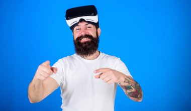 Sakal ve bıyık Vr gözlük, mavi arka plan ile olan adam. VR teknolojisi kavramı. Mutlu yüz ileriye işaret parmağı ile işaret hippi. Adam Vr gözlük veya baş ile görüntü monte