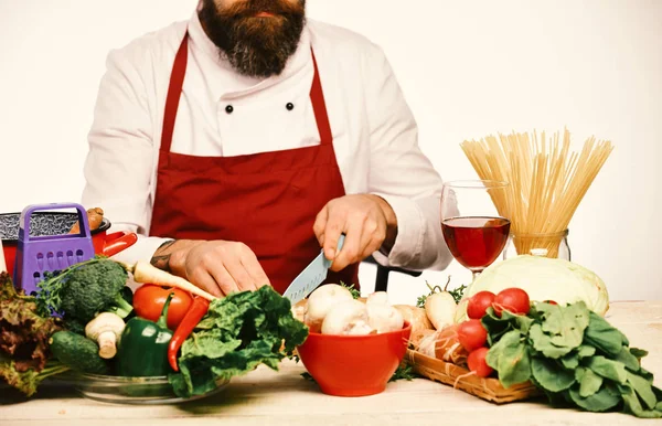 Cuocere con barba uniforme bordeaux verdure tagliate. Concetto di cucina professionale . — Foto Stock