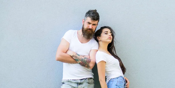 Jeugd stijlvolle outfit. Paar vrienden hangen samen grijs muur achtergrond. Het gevoel van hun stijl. Paar witte shirts knuffelen elkaar. Hipster met baard en stijlvolle meisje hang stedelijke romantische datum — Stockfoto