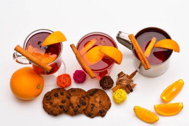 Kavram hizmet veren Bar. İçmek ya da portakal ve tarçın gözlük ve metal kupa, üstten görünüm ile içecek sıcak. Gözlük ve kupa turuncu ve beyaz arka plan, çerezleri mulled şarap ile yakından