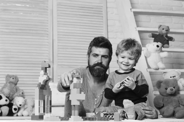 Hombre con barba y niño juegan sobre fondo de pared de madera. —  Fotos de Stock