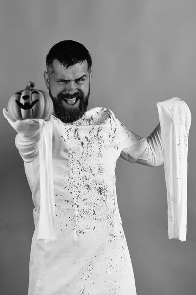 El tipo con barba sostiene calabaza naranja con sonrisa. Concepto Halloween — Foto de Stock