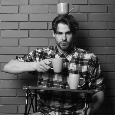 Duvarda bardakları tutan yakışıklı adam.