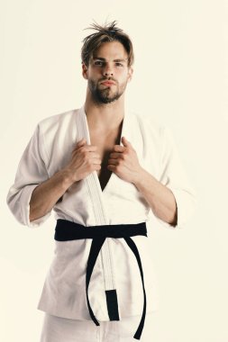 Adam siyah kuşaklı beyaz kimonoyla poz veriyor.