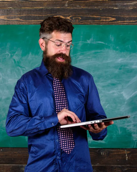 현대 기술 교육입니다. 레슨을 시작 합니다. 교사는 현대 노트북 칠판 배경으로 남자 수염. Hipster 교사 착용 안경, 넥타이 노트북 보유 하고있다. 디지털 기술 교육 — 스톡 사진