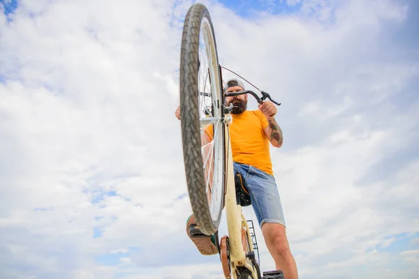 Homme barbu hipster promenades vélo fond ciel vue. Surmonter les obstacles à vélo. Hipster prêt à faire un tour. Optimiser les performances cyclistes. Culture cycliste moderne — Photo