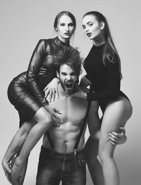 Kerl mit nackten muskulösen Oberkörper und zwei sexi Freundinnen — Stockfoto